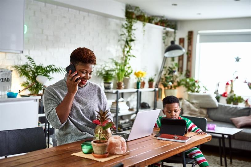 Mother working remotely next to her son