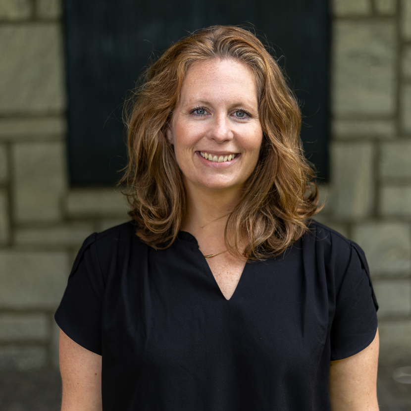 Marie Lamonica headshot in front of stone wall.