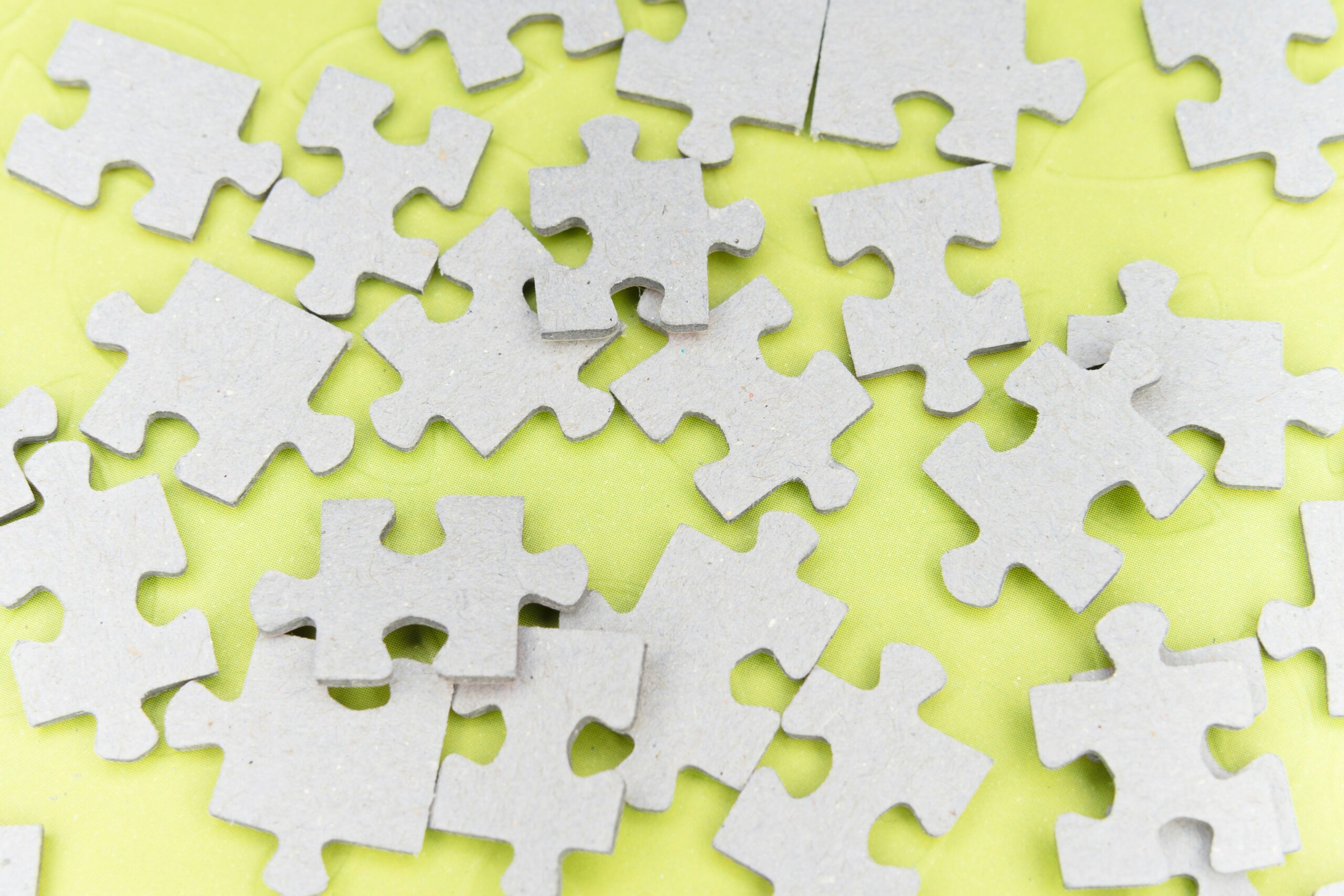 White puzzle pieces scattered on yellow background.